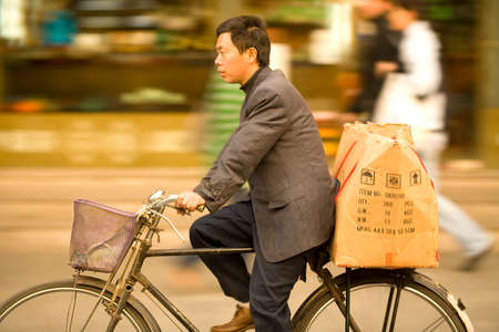Shanghai, Old Town, China, Asia - A camera pannning of a man riding a bicycle in font of the markets of Yuyuan Gardens in Old Town Shanghai.のeditorial素材