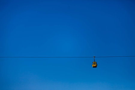 Color picture of a single yellow cable car cabin