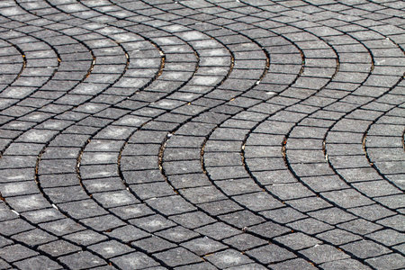 Grey pavement waves shape handmade sidewalk closeup
