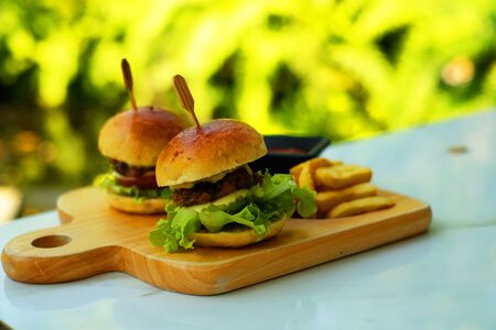 Twin pork hamburgers on wood cutting boardの写真素材