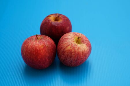 Three red apples on blueの写真素材