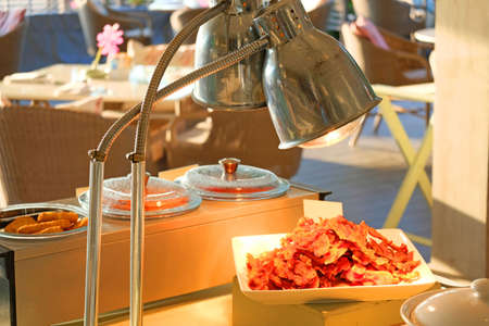 Fried crispy bacon served in white plate at a restaurant by the seaの写真素材