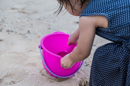 The girl is playing sand at the beachの写真素材