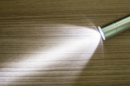 The flashlight shines on the wooden floor.の写真素材