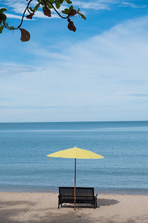 The lounge chairs and yellow umbrellas are laid out on the beach at the resort.の写真素材
