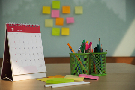 Conference room with colorful writing equipment on wooden desk and note pad on glass wall.の写真素材