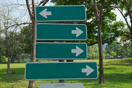 Signboard with green background and direction arrows in the public park.の写真素材