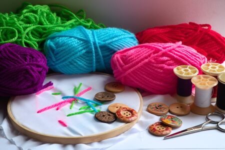 Embroidery accessories for a variety of colors, such as yarn, needle and buttons brought together...