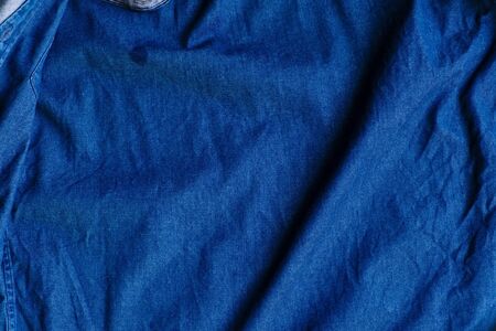 Blue denim fabric with crumpled wrinkles texture background.