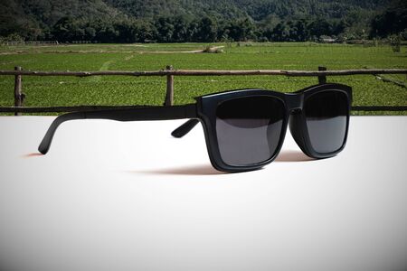 Abstract illustrations meaning the vision of leader by  the image of the sunglasses and the undeveloped green area background.の写真素材