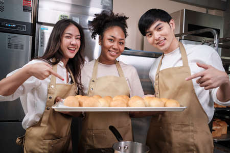 Portrait of three pastry startup partners looking at camera with a cheerful smile and proud with...