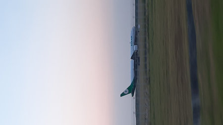 Aeroplane taking off from the airport runway at sunset.の写真素材