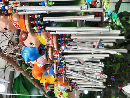 Colorful wooden toys hanging on the tree in the street market.の写真素材