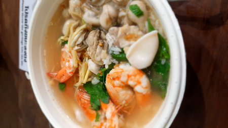 Thai style noodle soup with shrimp in white bowl on wooden tableの写真素材