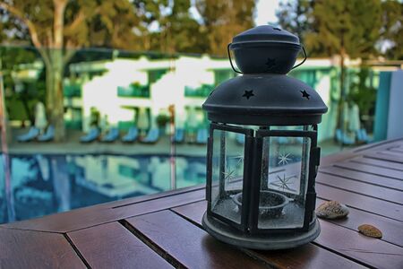 the lantern on the wooden table with shells over poolsideの写真素材