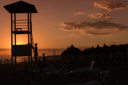 back lighted lifeguard tower with sunset over beachの写真素材