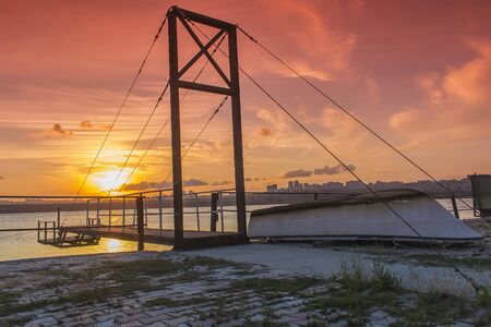 Small Boat Near the Wooden Pier that suspended with Sunsetの写真素材