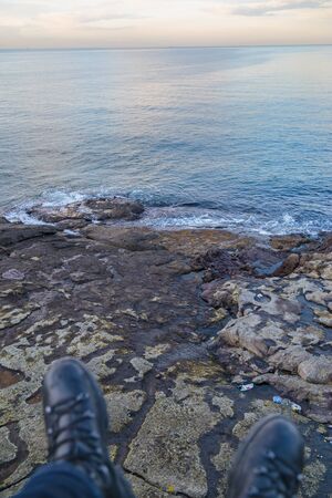 Cliff of Istanbul, Northest Point of Bosphorus, man sitting on the rocks by the sea with his foots,...
