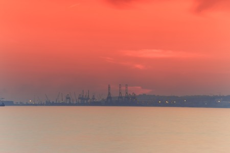 Hazy and dust view of commercial ship port during the sunset with Silky Sea ND Filter image for designの写真素材
