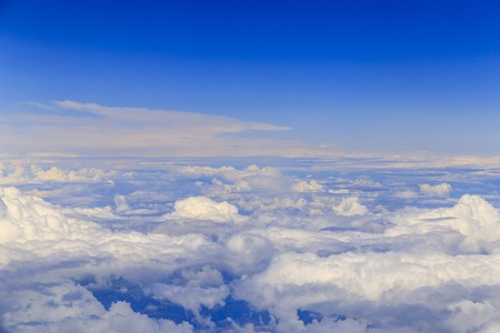 Big white clouds at blue sky view from the airplane seat
