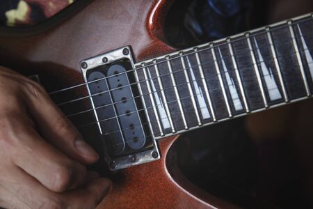 man playing electric guitar close up view, very shallow depth of field image, cinematic effect appliedの写真素材
