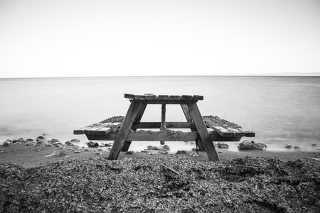 Single bench near the sea with long exposure image, b&W effect appliedの写真素材