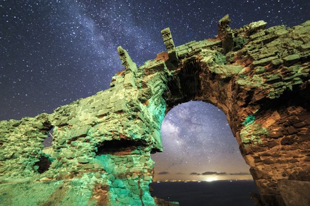 Milky way view from old ruined stone gateの写真素材