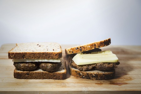 Homemade diet hamburger over wooden flat, yellow filter appliedの写真素材