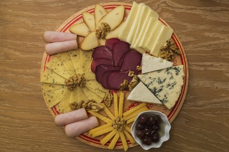 Cheese Board over Wooden Table With smoked meatの写真素材