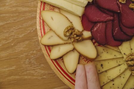 Cheese Board over Wooden Table With smoked meatの写真素材