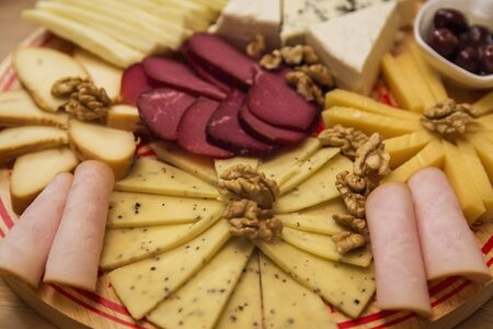 Cheese Board over Wooden Table With smoked meatの写真素材