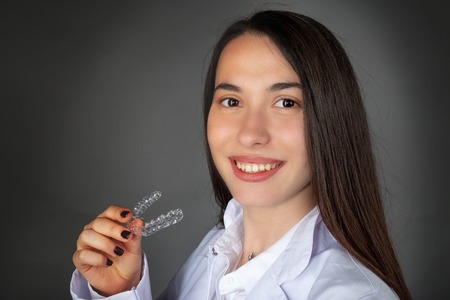 Beautiful smiling Turkish girl keeping invisaligner on her hand