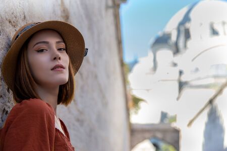 Beautiful girl with orange colored dress posing in front of the Suleymaniye Mosqueの写真素材