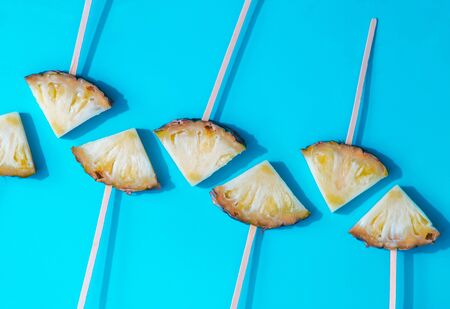 Minimal view of Sliced pineapple ripes on blue pastel backdrop, flat lay view with copy spaceの写真素材