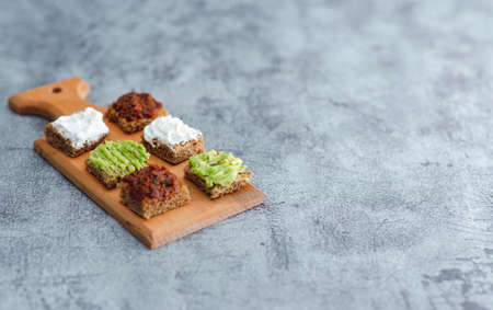 Close up detail view of bread bites with colorful tapas over rustic backdrop with copy spaceの写真素材