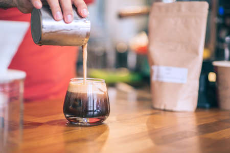 Barista is prepring a cold brew in a vintage designed coffee shop. Closeup detail view with copyspace.の写真素材