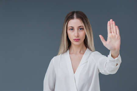 Beautiful blonde woman gesture and sign concept. She raised her hands and expressing stop the harassment abuse concept. Includes copy space.の写真素材