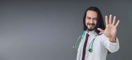 Handsome Young Italian male doctor gesturing his hand as five signs.の写真素材
