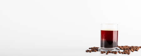 Isolated espresso shot view with coffee beans over white.の写真素材