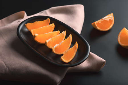 Sliced orange citrus view over black background, includes copy space.