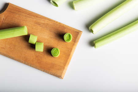 Minimal flat lay looking leeks view during slice progress over white, indludes copy space.の写真素材