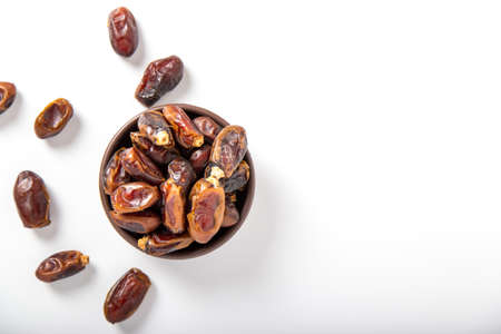 Flat lay view of dried ramazan date fruit over white with copy space.