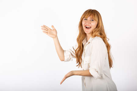 Happy young businesswoman portrait in isolated studio, she is pointing empty copy space.の写真素材