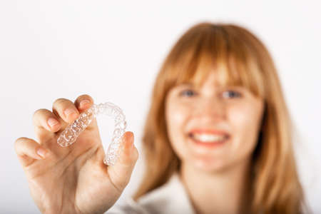 Happy young woman with invisible teeth aligner.