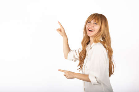 Happy young businesswoman portrait in isolated studio, she is pointing empty copy space.の写真素材