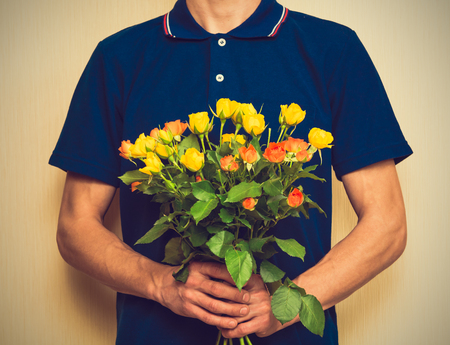 Man holding bouquet of yellow and orange roses. Women' s day, Valentines Day, Mothers day. Selective focus, tonedの写真素材