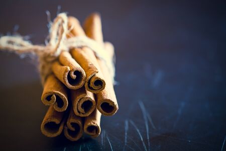 Bunch of cinnamon sticks on black background. Selective focus, tonedの写真素材