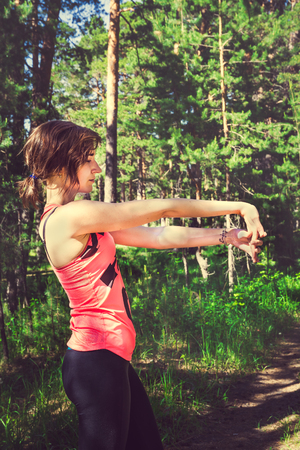 Young fitness woman runner stretching before run. Runner athlete jogging workout wellness concept. Selective focus, tonedの写真素材