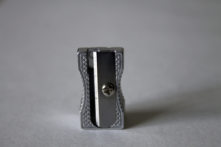 Metal pencil sharpener close-up on the paper for drawingの写真素材