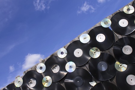 Vinyl plates and cracked disks are screwed to the fence, diagonal upの写真素材